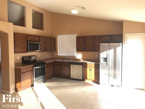 A kitchen with brown cabinets and a refrigerator.