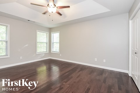 A room with wooden flooring and a ceiling fan.