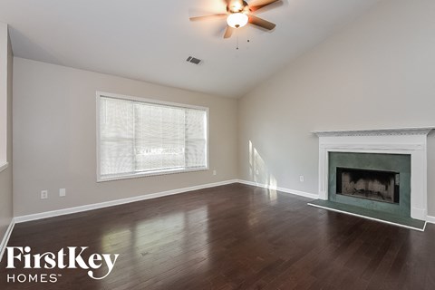 A room with a fireplace and a ceiling fan.