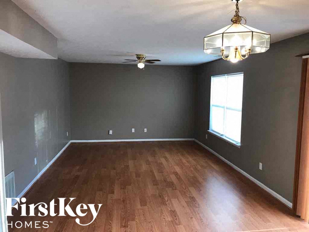 A room with wooden floors and a hanging light fixture.