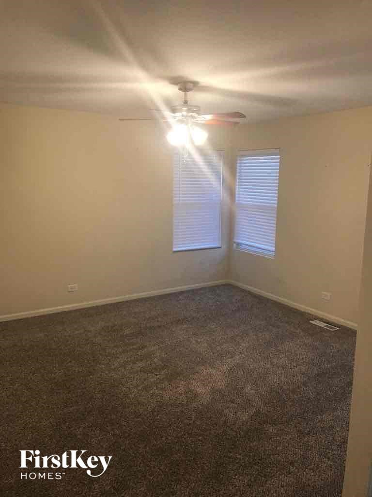 an empty room with a ceiling fan and a window