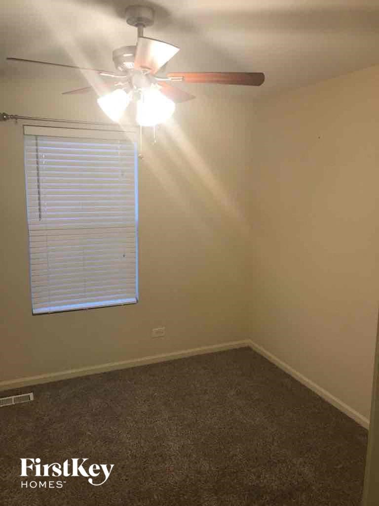 a bedroom with a ceiling fan and a window
