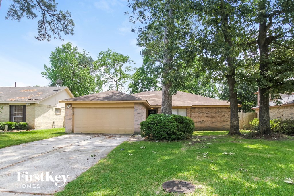 a side view of a house with trees and a driveway