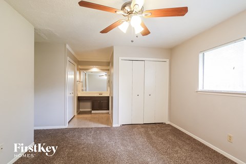 a living room with carpet and a ceiling fan