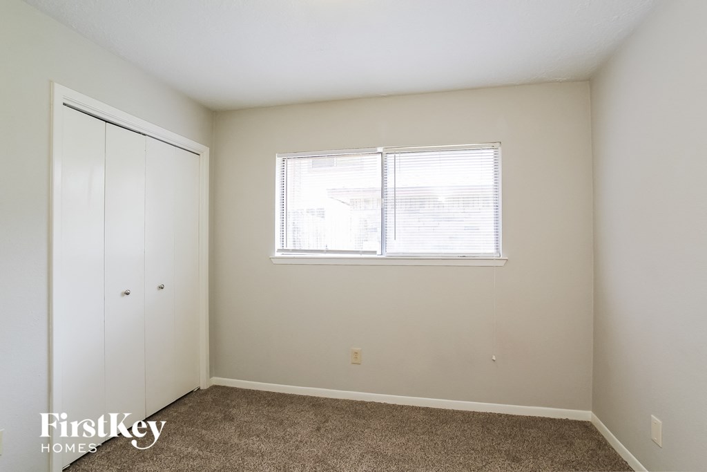 a bedroom with a window and a closet