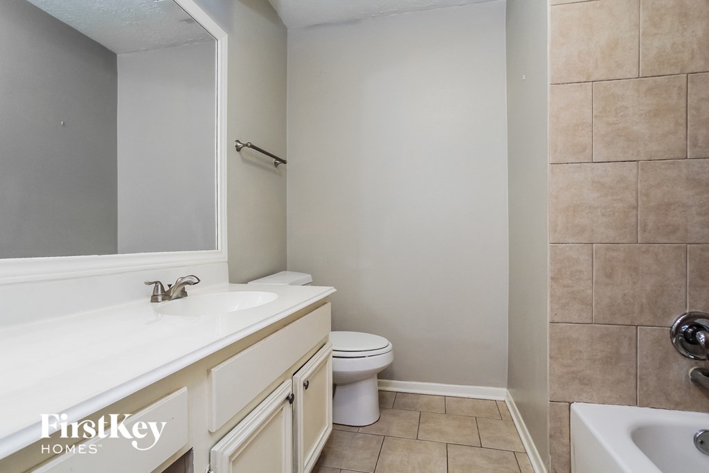 a bathroom with a sink toilet and a mirror