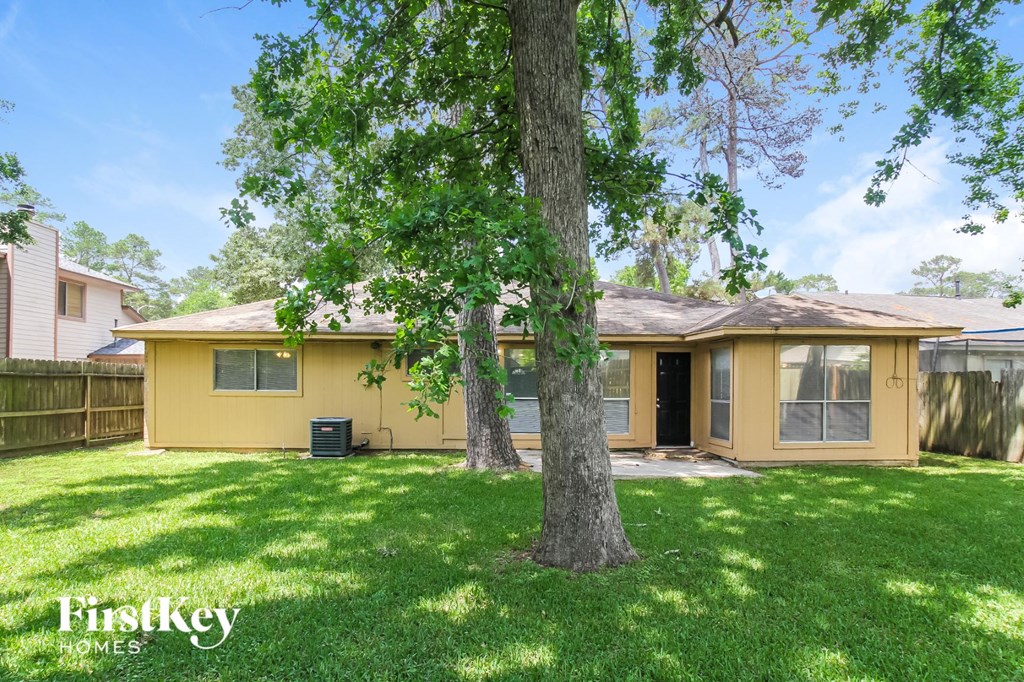 a yellow house with a tree in the yard