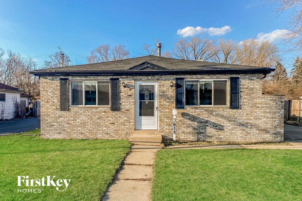 a small brick house with a sidewalk in front of it