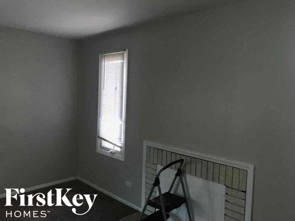 a room with a window and a tripod in the corner