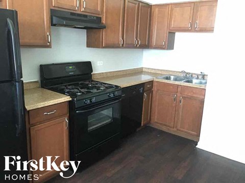 an empty kitchen with black appliances and wooden cabinets