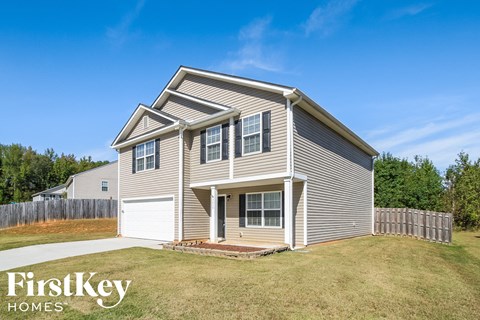 A two-story house with a garage is showcased in the image.