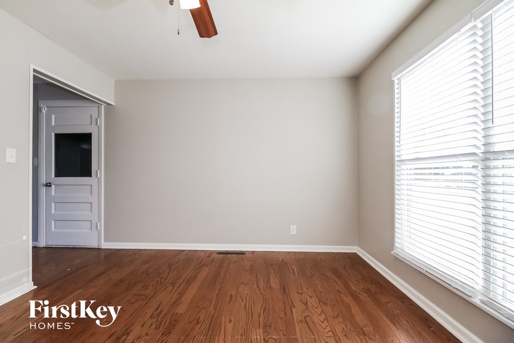 the living room with wood floors and a door to the hallway
