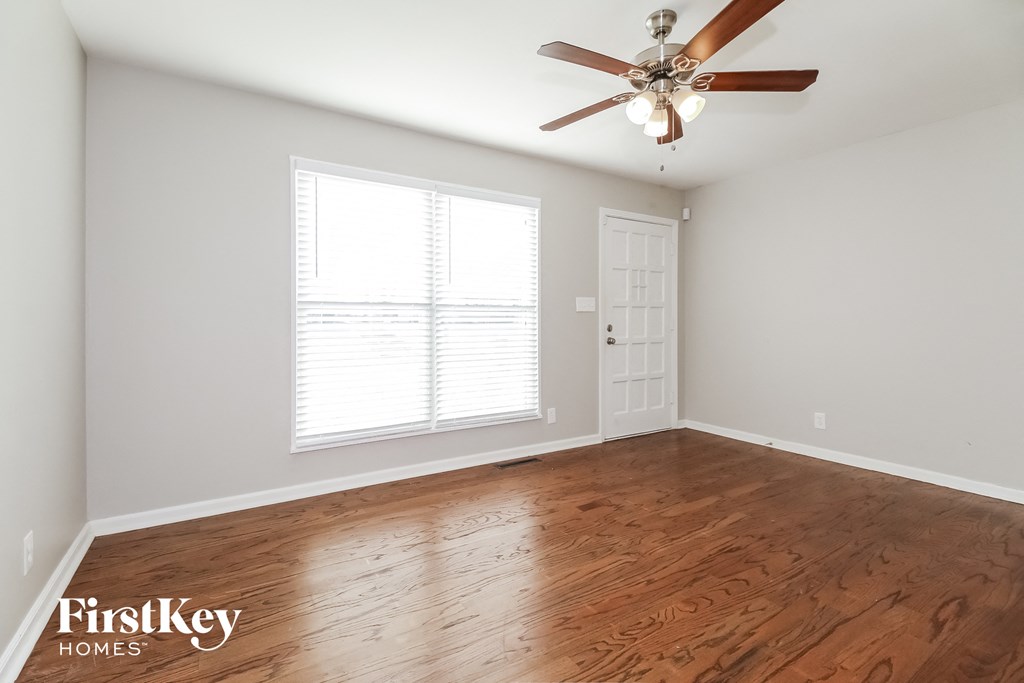 the living room with hardwood floors and a ceiling fan