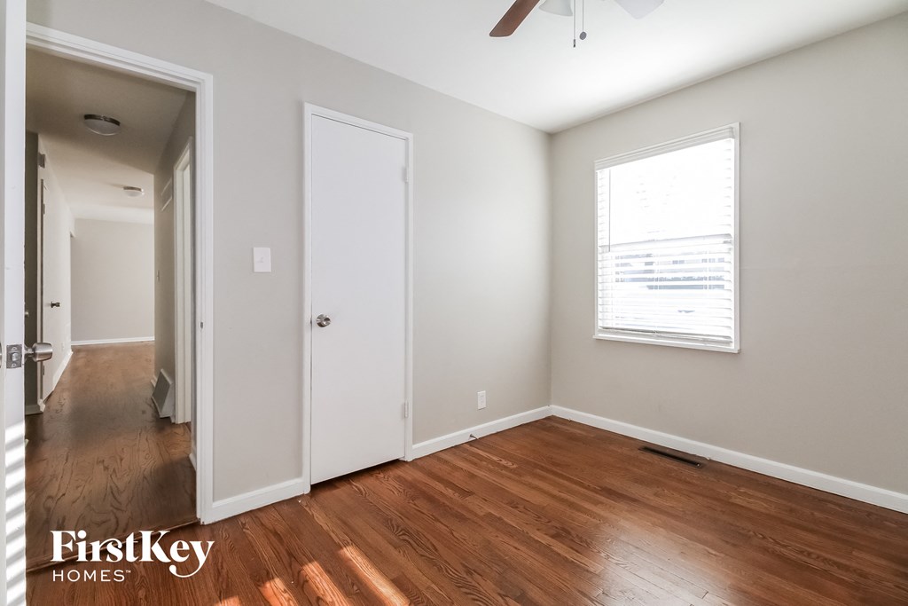 the living room of an empty house with wooden floors and a window