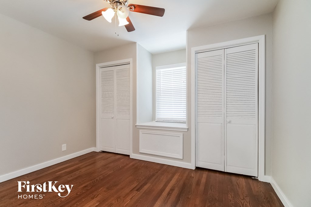 an empty room with a ceiling fan and a window