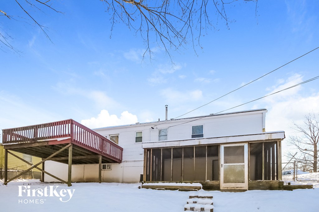 a white house with a red deck in the snow