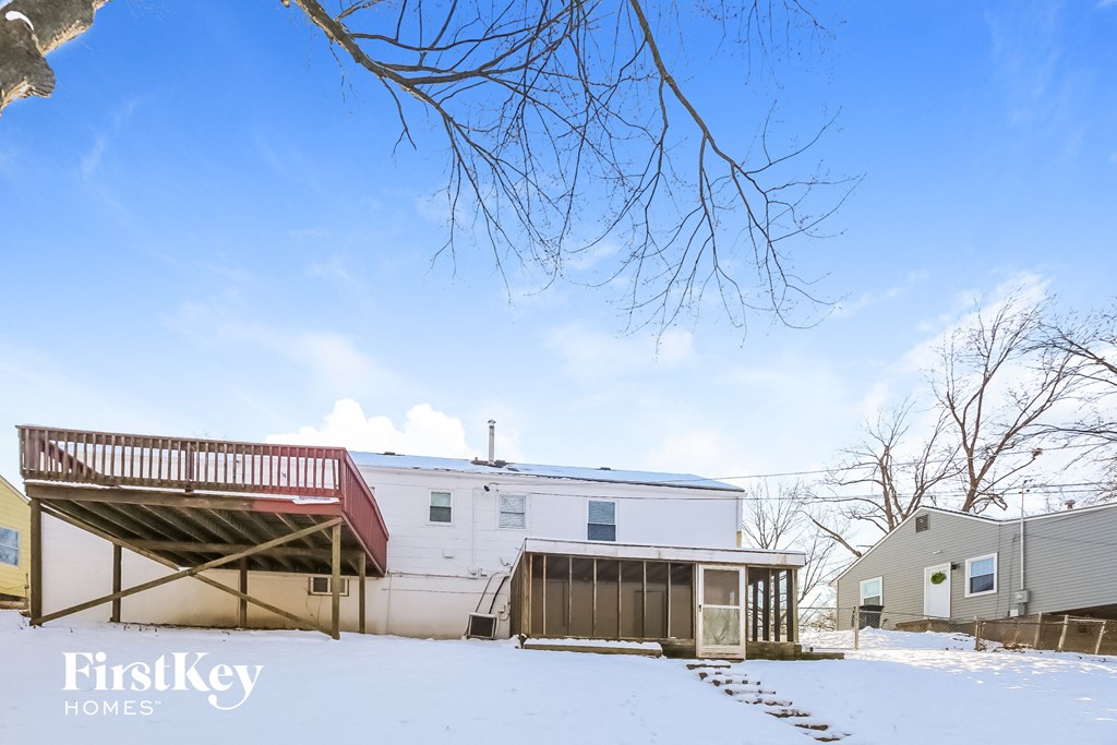 a white house with a deck in the snow