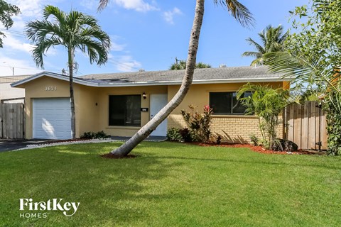 a palm tree leaning into the lawn in front of a house