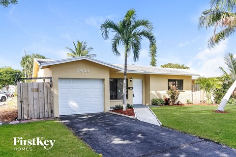 a home with palm trees and a white garage door