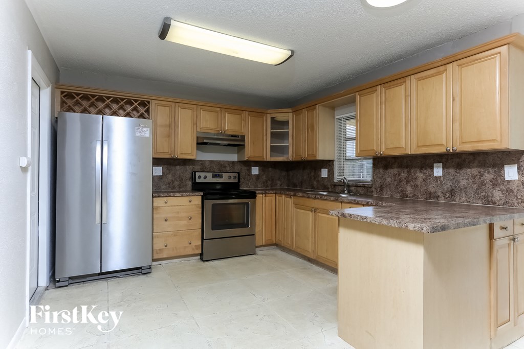 a kitchen with wooden cabinets and a stainless steel refrigerator