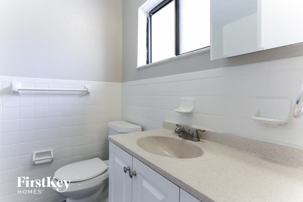 a bathroom with a sink and a toilet and a window