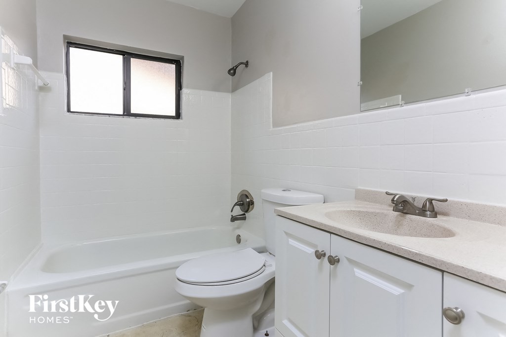 a white bathroom with a toilet and a sink