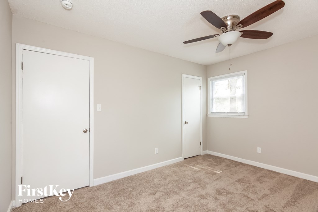 a bedroom with a ceiling fan and a closet