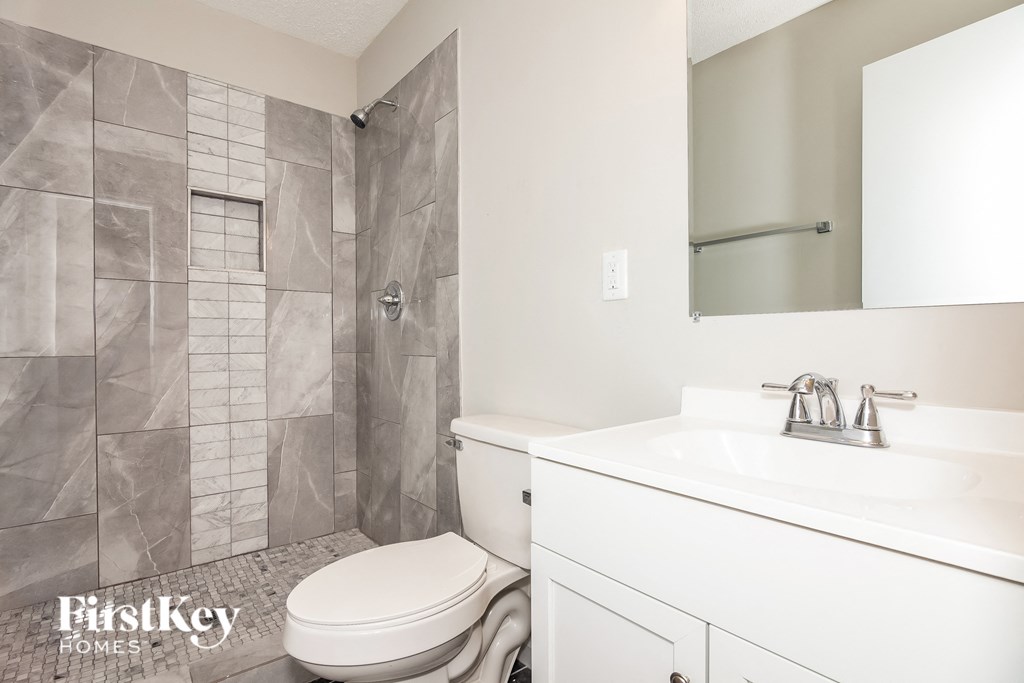 an image of a bathroom with a toilet sink and shower