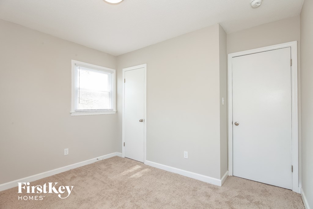 a bedroom with a door to a closet and a window