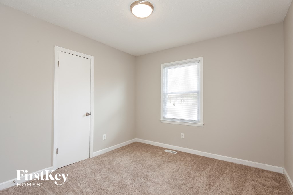 a bedroom with a carpeted floor and a white door