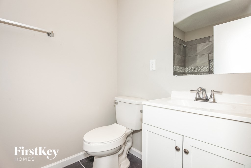 a white bathroom with a toilet and a sink