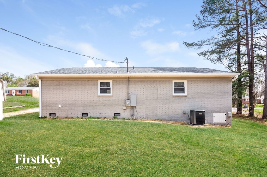 the front of a house with a green lawn and trees