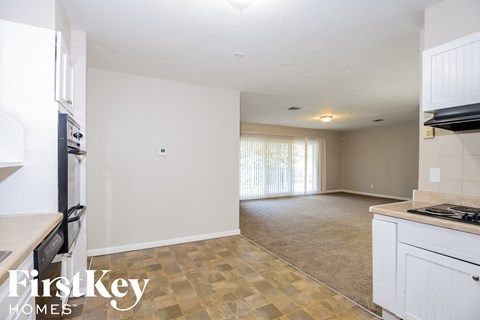 A kitchen with a tile floor and a stove top oven.