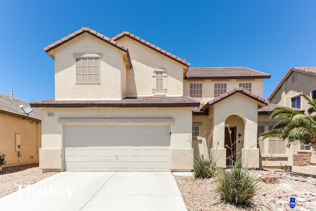 A house with a garage and a driveway in front of it.