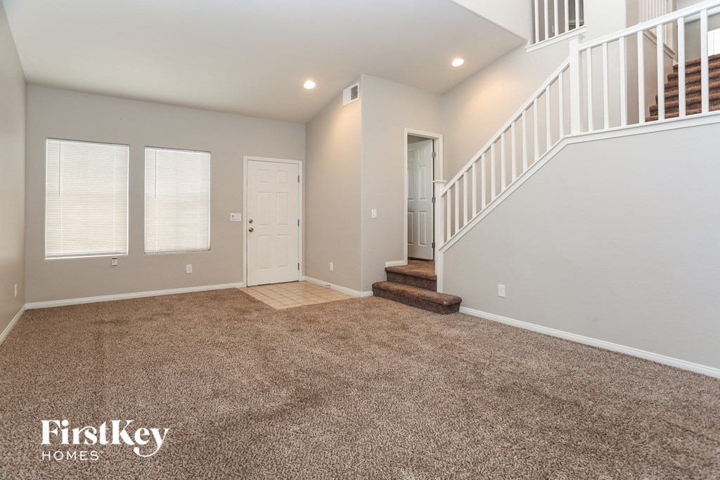 A spacious room with a staircase and two doors.