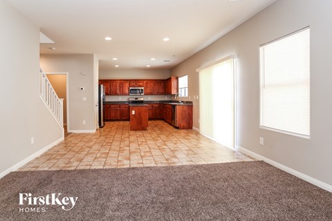 A spacious kitchen with wooden cabinets and a tiled floor.