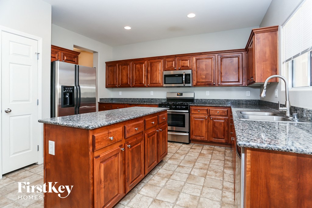 A kitchen with wooden cabinets and granite countertops.