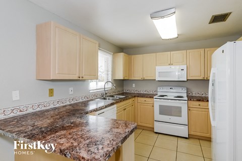 a kitchen with white appliances and granite counter tops