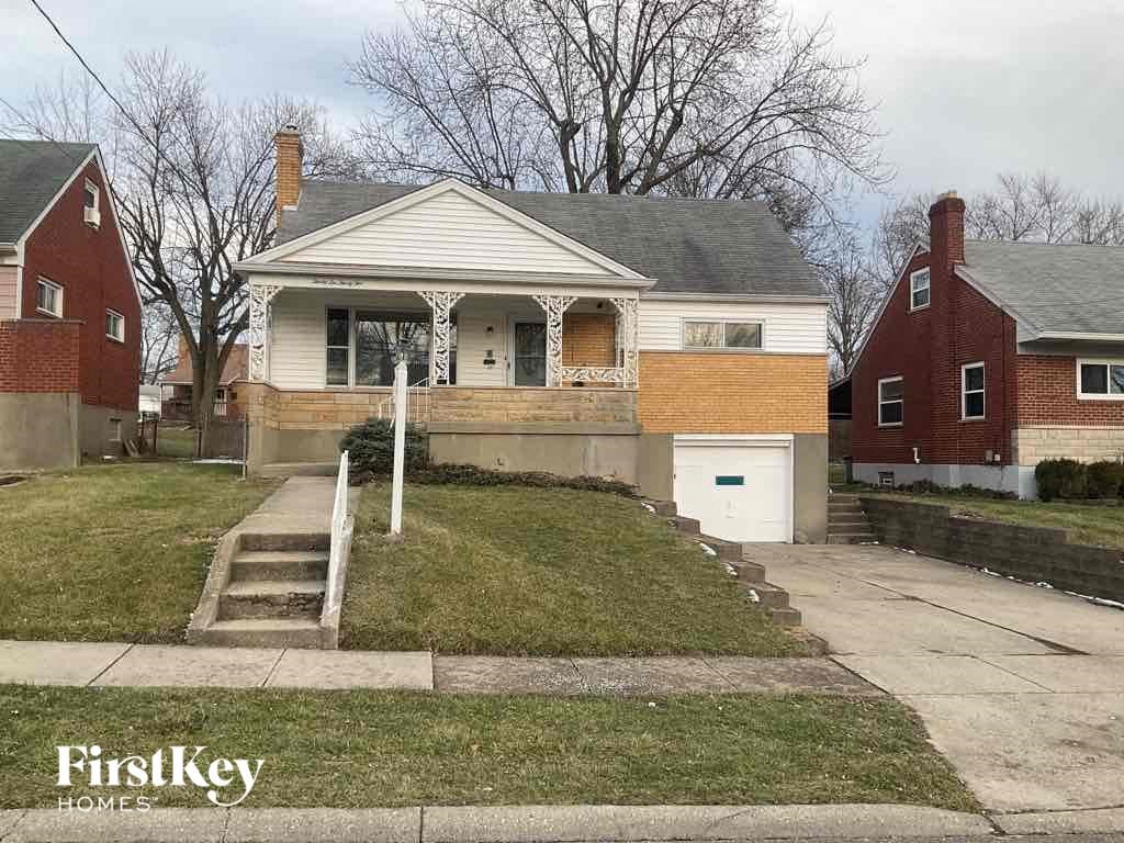 the front of a house with stairs and a driveway