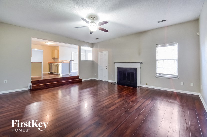 an empty living room with wood floors and a fireplace