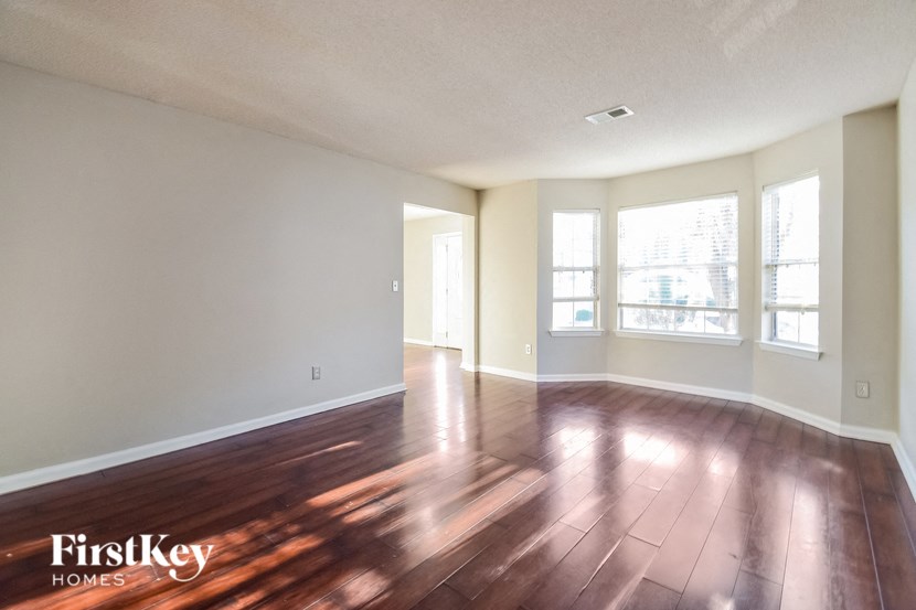 the living room and dining room of an empty house with wood floors