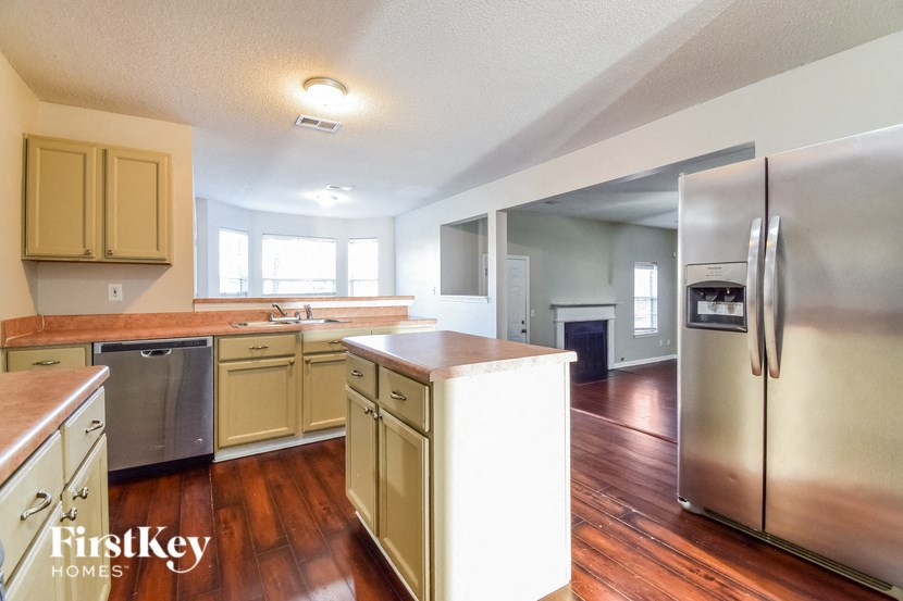 a kitchen with wooden floors and stainless steel appliances