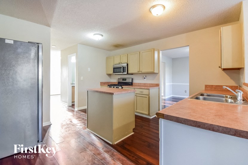 a kitchen with white cabinets and stainless steel appliances and a hard wood floor