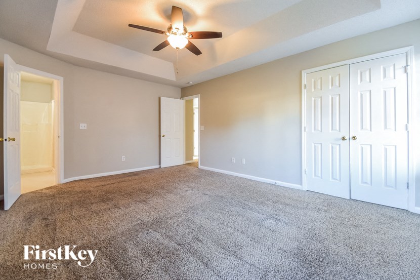 the living room of an empty house with a ceiling fan