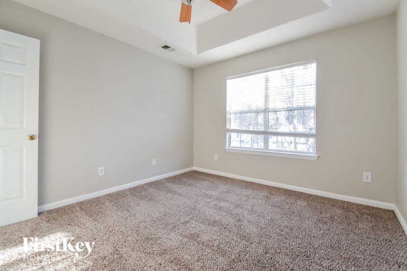 an empty living room with carpet and a window