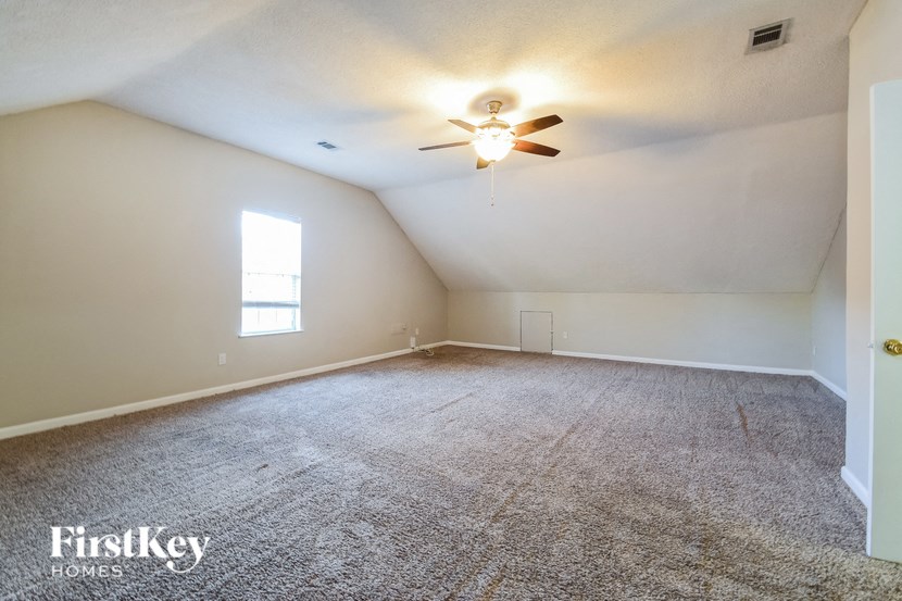 the living room of an empty house with a ceiling fan