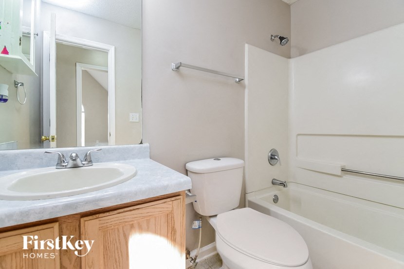 a bathroom with a toilet sink and tub and a mirror