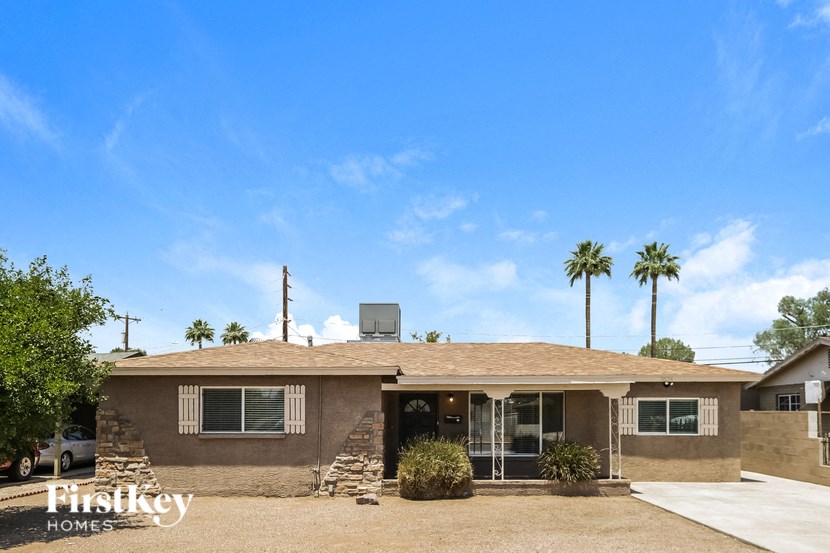 a house with palm trees in the background and a blue sky