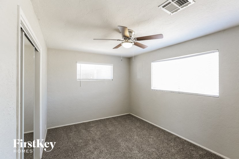an empty room with a ceiling fan and a window