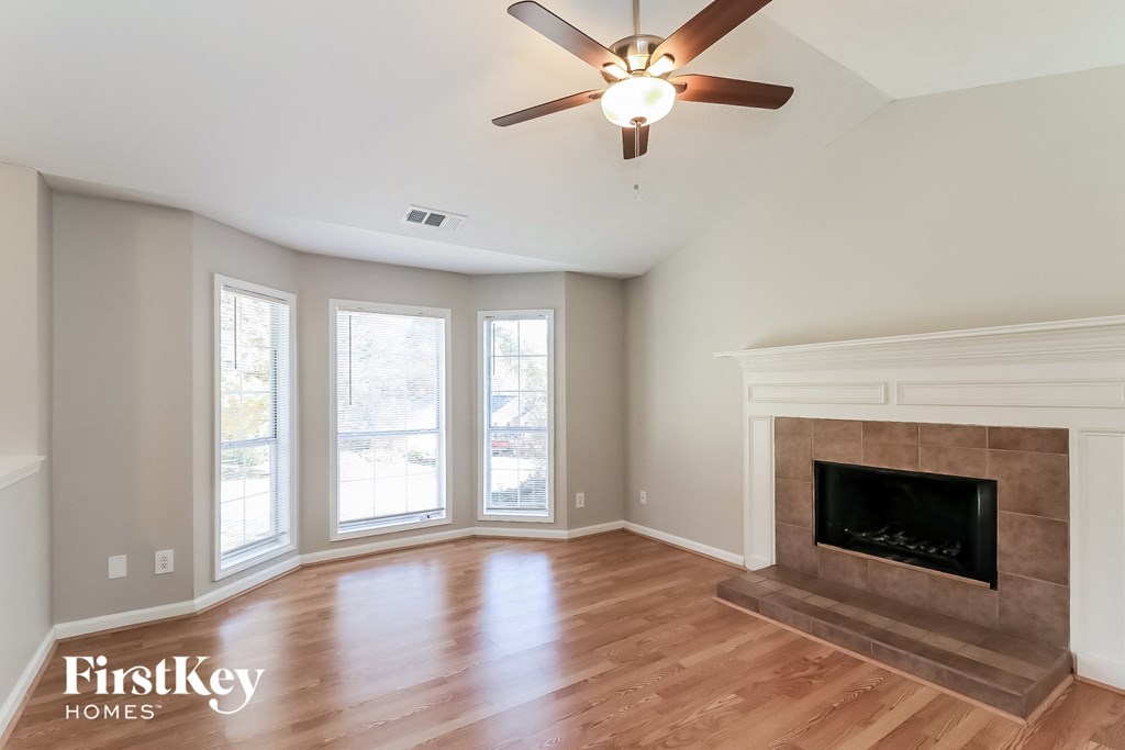 a living room with a fireplace and a ceiling fan